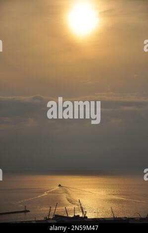 Agosto tramonto durante l'ora d'oro sopra la baia vicino a Rijeka, Croazia, piccola barca silhouette visibile sull'acqua. Foto Stock