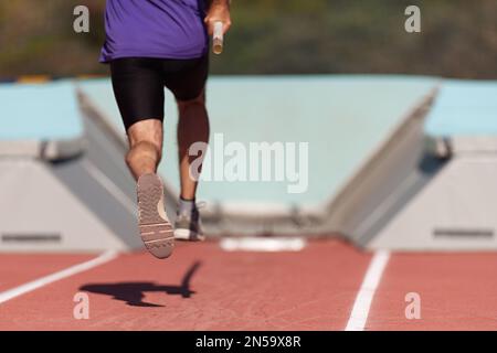Corsa-up atleta maschio pole volta alla concorrenza atletica Foto Stock