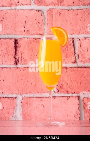 Rinfrescanti cocktail Mimosa all'arancia con champagne su sfondo luminoso. Foto Stock