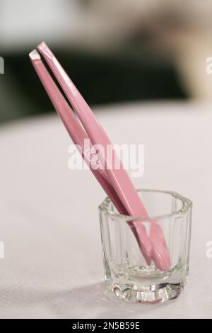 Pinzette per le sopracciglia. Focus sulla macro delle pinzette di correzione delle sopracciglia Foto Stock