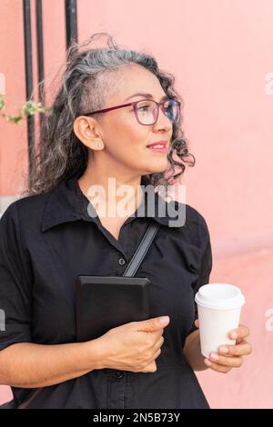 Donna alla moda in occhiali può tenere il tablet all'aperto. Foto Stock