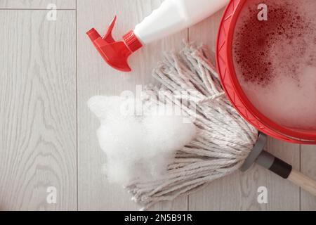 Secchio, spazzolone e bottiglia di prodotto detergente su pavimento interno, piano Foto Stock
