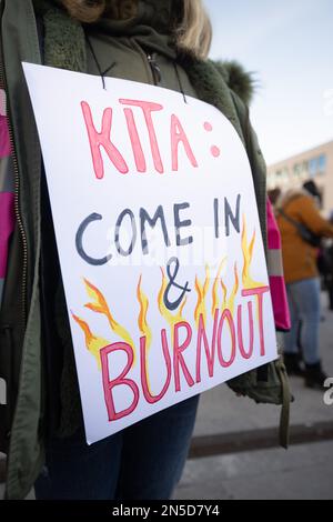 Fulda, Germania. 09th Feb, 2023. "Kita: Come inn & burnout" è scritto su un cartello portato da una donna durante uno sciopero di avvertimento da parte dei dipendenti del settore pubblico. L'appello è stato fatto dall'associazione dei funzionari pubblici dbb e dal sindacato Komba. I sindacati chiedono un reddito superiore del 10,5 per cento, ma almeno 500 euro in più per i circa 2,5 milioni di dipendenti del settore pubblico delle amministrazioni federali e locali. Credit: Sebastian Gollnow/dpa/Alamy Live News Foto Stock