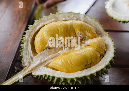 Il re dei frutti si aprì a metà su una tavola. Frutti tropicali ed esotici provenienti dalla Malesia, Sud Est Asiatico. Varietà Musang King. Foto Stock