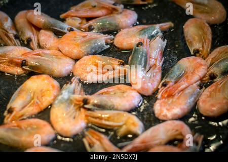 Gamberetti fritti con salsa di soia, aglio in olio in padella frutti di mare tradizionale cibo tailandese. Foto Stock