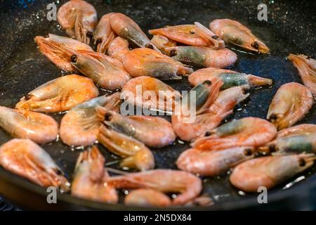 Gamberetti fritti con salsa di soia, aglio in olio in padella frutti di mare tradizionale cibo tailandese. Foto Stock