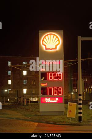 Zutphen, Paesi Bassi - 27 gennaio 2023: Grande colonna informativa di notte con prezzi del carburante presso una stazione di servizio Shell Foto Stock