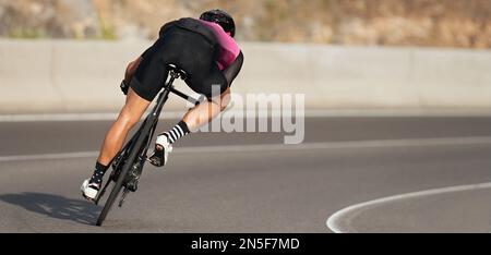 Bici da strada ciclista uomo ciclismo, atleta su una bicicletta da corsa. Appoggiandosi in un angolo. Cicloturismo professionale maschile che prende una posizione aerodinamica della carrozzeria Foto Stock