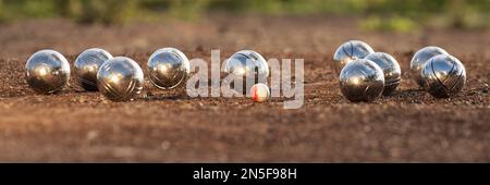 Palle di petanque bocce bocce bocce in primo piano su sfondo campo di ghiaia di sabbia, gioco di petanque sul terreno. Sfere e un piccolo cric di legno Foto Stock