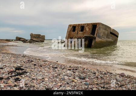 Edifici abbandonati sulla riva del mare in acqua. Rovine di guerra che si decompongono nel Mar Baltico. Ex bunkers forte a Liepaja, Lettonia. Foto Stock
