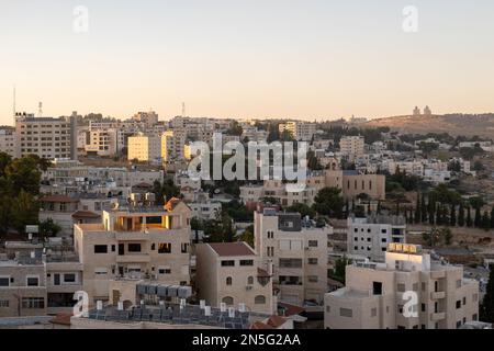 Betlemme, Cisgiordania, Palestina - 22 luglio 2022: Paesaggio urbano al tramonto con i raggi dell'ultimo sole sugli edifici in pietra bianca Foto Stock