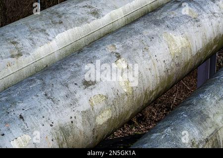 primo piano di grandi tubi metallici di teleriscaldamento affiancati Foto Stock