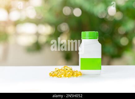 Capsule di olio di fegato di merluzzo la vitamina omega 3 che si posa sul pavimento accanto alla bottiglia della pillola. Foto Stock