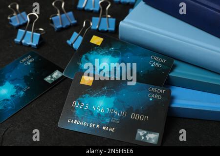 Carte di credito e cancelleria su sfondo nero, primo piano Foto Stock