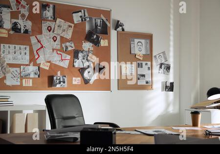 Interno ufficio detective con grande scrivania in legno e lavagna di prove Foto Stock