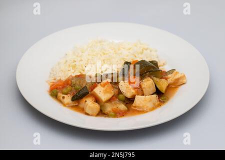 stufato di calamari con verdure e riso bollito su piatto bianco Foto Stock