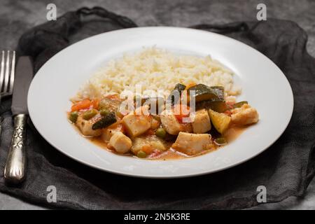 stufato di calamari con verdure e riso bollito su piatto bianco Foto Stock