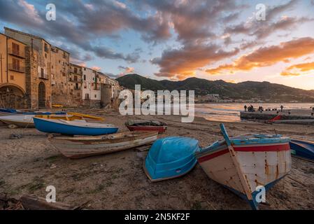 Tramonto sulle barche da pesca nella spiaggia di Cefalù, in Sicilia Foto Stock