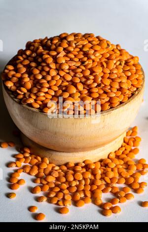 Lenticchie di colore giallo in una ciotola di legno isolata su fondo bianco. Il lenticchie è cibo comune della gente asiatica Foto Stock