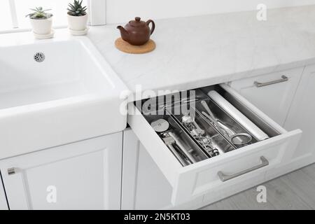 Cassetto aperto con utensili diversi in cucina Foto Stock