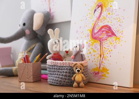 Cancelleria, foto e giocattoli su tavolo in legno nella stanza dei bambini. Design degli interni Foto Stock