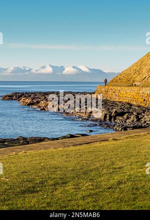 Vista sul Firth of Clyde fino alle vette innevate dell'isola di Arran dal lungomare di Troon Foto Stock