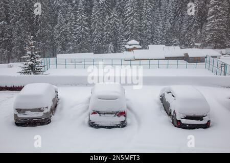 Auto sotto uno strato spesso di neve. Tre veicoli innevati durante una Blizzard invernale Foto Stock