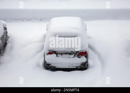 Auto sotto uno strato spesso di neve. Veicoli innevati durante una Blizzard invernale Foto Stock