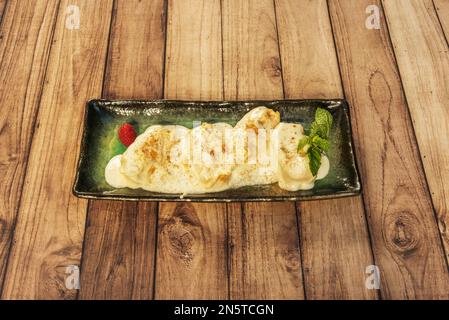 Panzerotti di pasta fresca ricoperta di salsa su un piatto verde Foto Stock