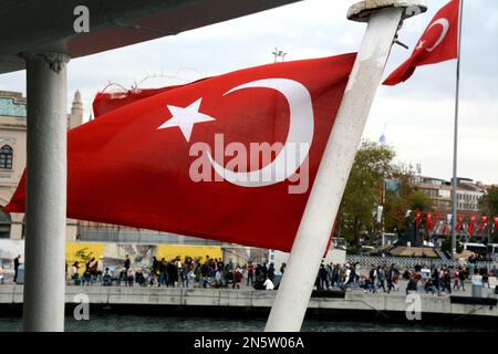 Un paio di bandiere turche che sventolano al vento al terminal della stazione dei traghetti di Kadikoy e al porto sul lato asiatico di Istanbul, in Turchia. Foto Stock