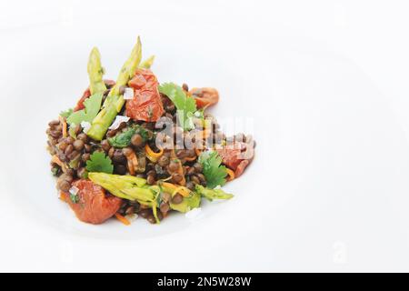 Delizioso piatto di lenticchie con pomodori e asparagi Foto Stock