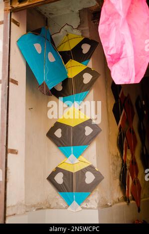 Uno scatto verticale di un aquilone di carta stampato appeso in blu, giallo e marrone nel haveli di Mandawa in Rajasthan India Foto Stock