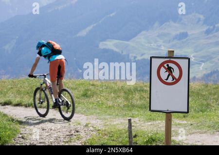 Mountain Biker pedalata su pista ciclabile con cartello segnaletico, Zillertal, Tirolo, Austria Foto Stock