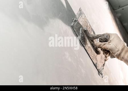 lavoro manuale con cazzuola per impermeabilizzare il muro Foto Stock