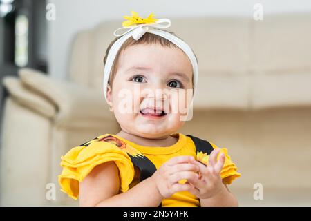 bella lattina, molto felice, sorridente e mostrando la lingua, indossa un abito giallo Foto Stock