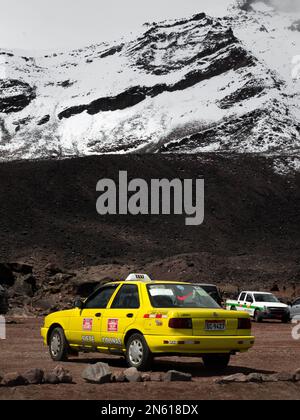 Un'immagine che mostra il contrasto tra un taxi colorato e il vulcano Chimborazo dall'Ecuador. Foto Stock