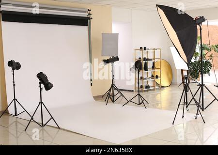 Interno di moderno studio fotografico con cicorama bianco e attrezzature Foto Stock