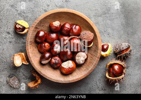 Castagne di cavallo in piatto di legno su tavolo grigio, piatto Foto Stock