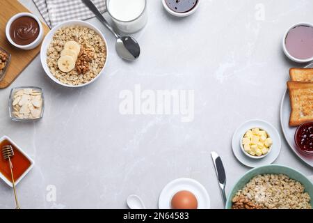 Composizione piatta con gustosi piatti per la colazione su un tavolo in marmo grigio chiaro. Spazio per il testo Foto Stock