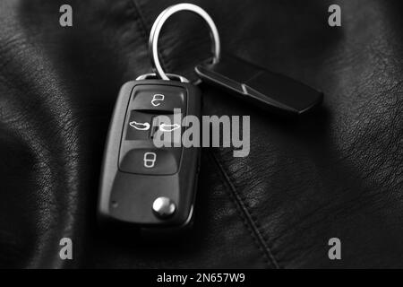 Chiave a scatto per auto moderna con trinket in pelle nera, primo piano Foto Stock