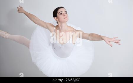 Ballare con grazia. Ballerina giovane e flessibile che balla su sfondo bianco. Foto Stock