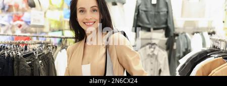 Donna alla moda che prova la borsa in pelle in negozio Foto Stock