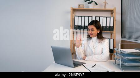 Medico di sesso femminile che ha video chiamata online consultazione sul computer portatile in ospedale. Medicina della Telesanità in India. Appuntamento per i pazienti con telemedicina. C Foto Stock