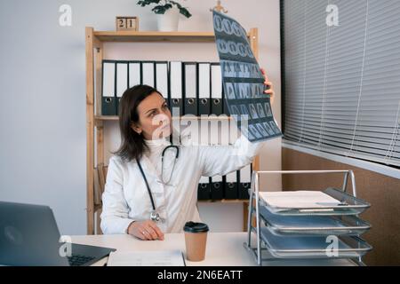 Personale sanitario o medico che guarda l'immagine radiografica del corpo, la risonanza magnetica, la scansione tc in clinica ospedaliera. Medico e sanitario conc Foto Stock