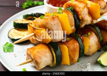 Deliziosi kebab di pollo shish con verdure sul piatto, primo piano Foto Stock