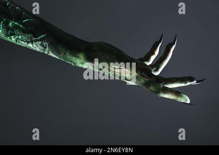 Mostro spaventoso su sfondo nero, primo piano della mano. Carattere di Halloween Foto Stock