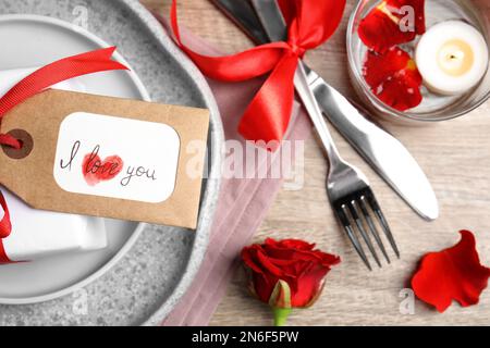 Bel posto impostazione e tag con frase ti amo su tavolo di legno, piatto. Cena romantica di San Valentino Foto Stock