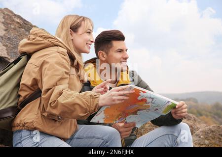 Coppia di viaggiatori con zaini e mappa che godono di una splendida vista nelle giornate di sole. Vacanze autunnali Foto Stock