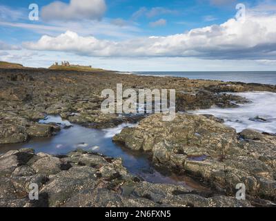 Il castello di Dunstanburgh da "Turner vista dell' sulla costa Northumbrian vicino al villaggio di Craster, Northumberland, Inghilterra Foto Stock