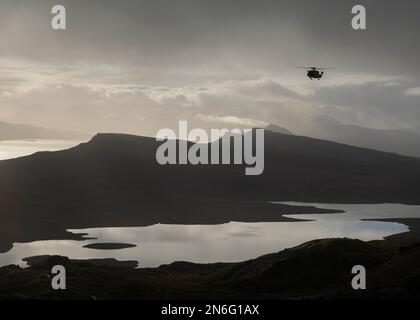 HM Coastguard elicottero volare sopra Loch Leathan con il suono di Raasay sullo sfondo, Isola di Skye, Scozia Foto Stock